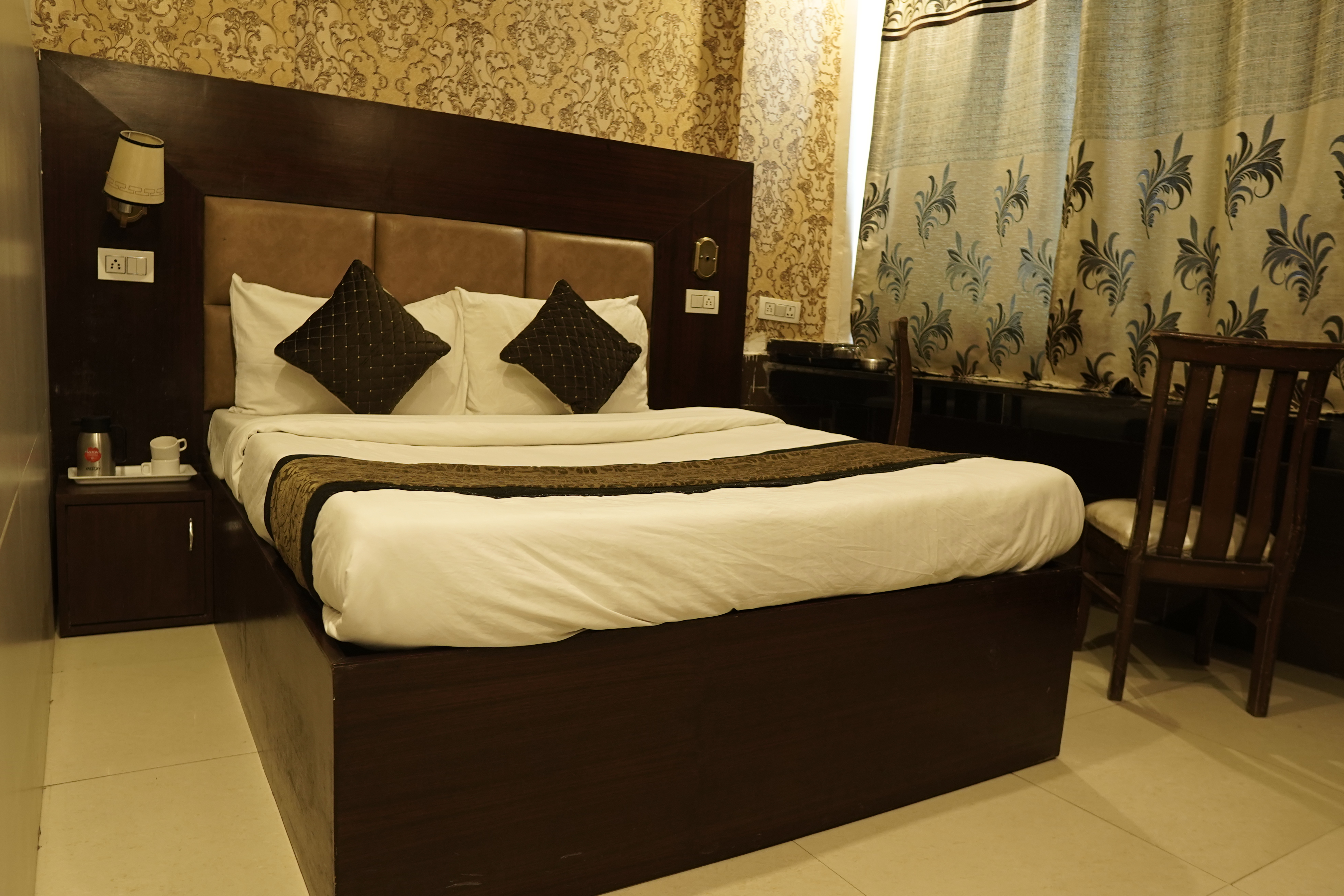 Deluxe Room at Hotel The Black Gold with queen bed and warm lighting